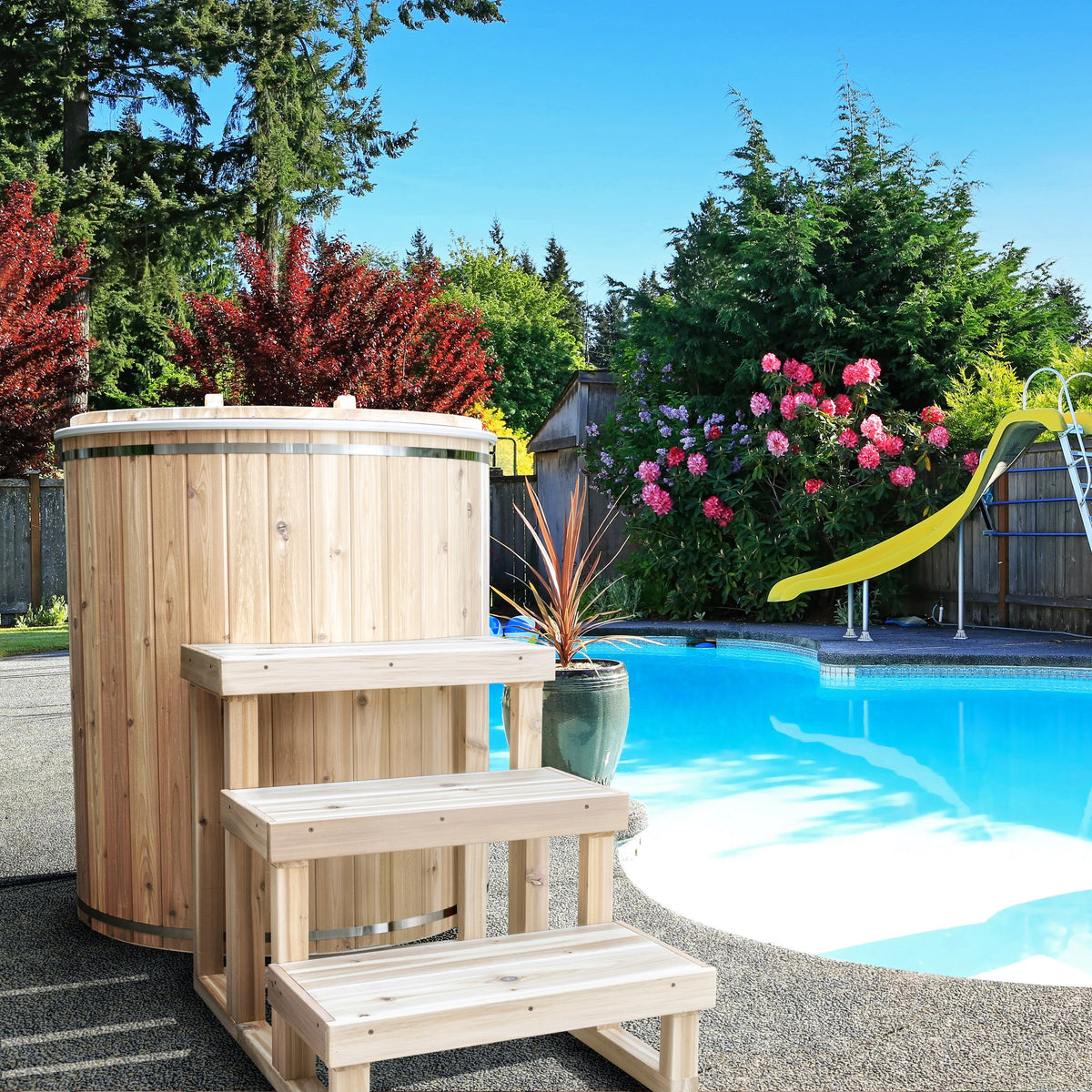 The Baltic Plunge Tub by LeisureCraft beside a backyard pool with three-tier cedar steps