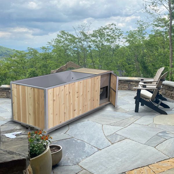 The Flow Cold Plunge on a flagstone patio overlooking mountains, cedar chiller-compartment door open