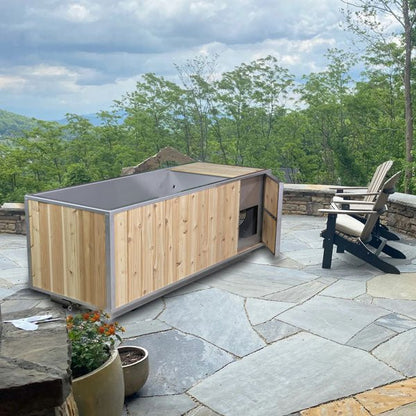 The Flow Cold Plunge on a flagstone patio overlooking mountains, cedar chiller-compartment door open