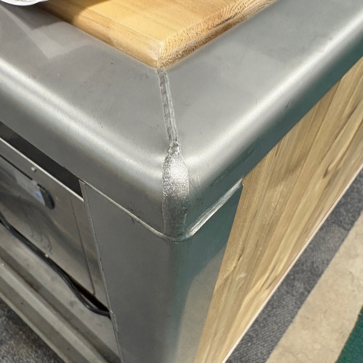Welded stainless corner and cedar top rail of The Flow Cold Plunge, close up
