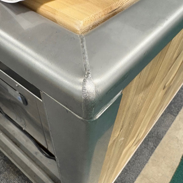 Welded stainless corner and cedar top rail of The Flow Cold Plunge, close up