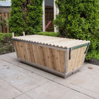 The Polar Plunge Tub by LeisureCraft on a patio with the cedar roll-up cover closed, cedar-clad angled sides