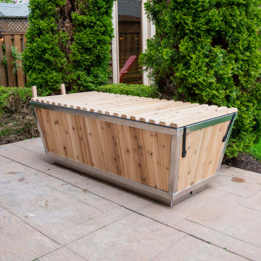 The Polar Plunge Tub by LeisureCraft on a patio with the cedar roll-up cover closed, cedar-clad angled sides