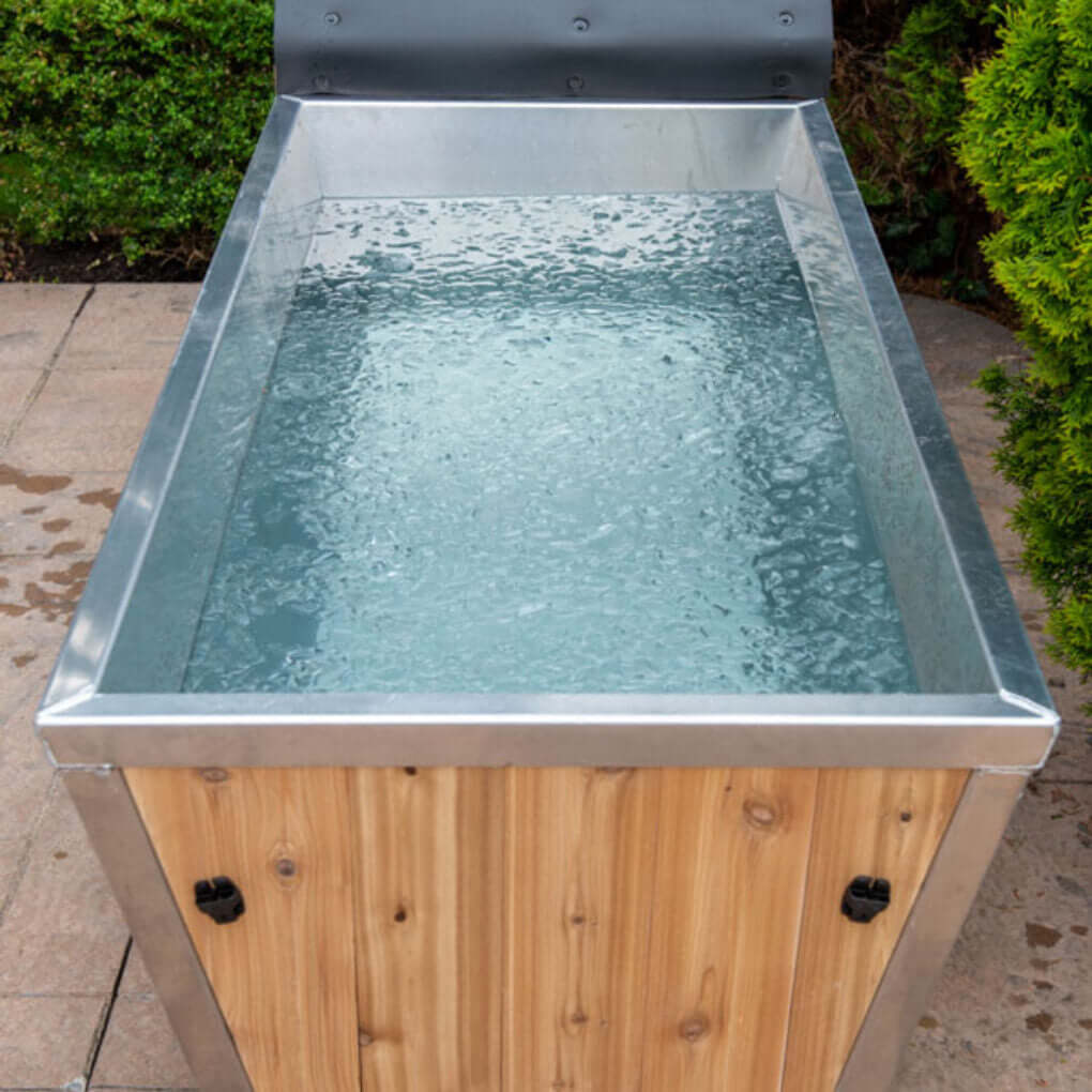 End view of The Polar Plunge Tub filled with water showing the 304 stainless interior and drain side