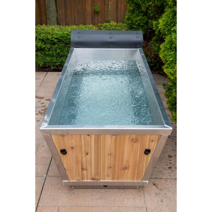 Front view of The Polar Plunge Tub filled with water, cedar roll-up cover pushed back