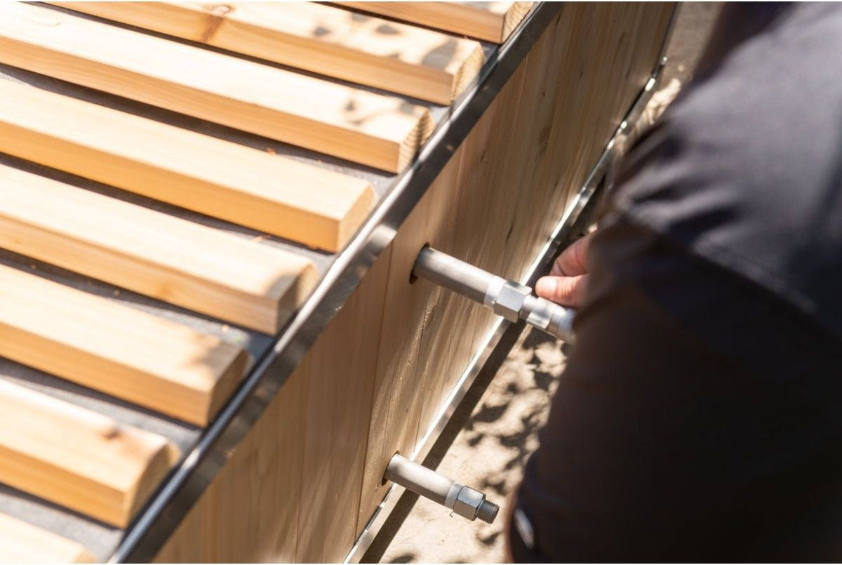 Two chiller fittings through the cedar side wall of The Polar Plunge Tub, roll-up cover slats above