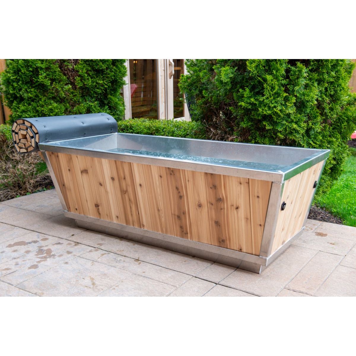 Cold water in The Polar Plunge Tub with cedar cladding and stainless rim, hedge behind