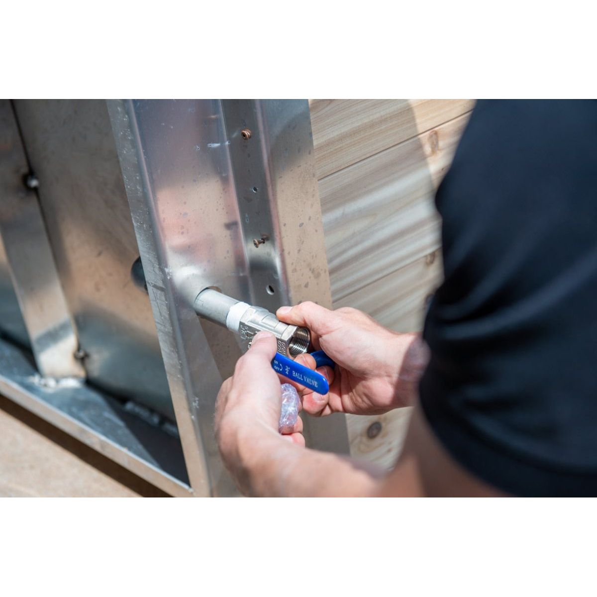Tightening a hose clamp on the chiller line of The Polar Plunge Tub