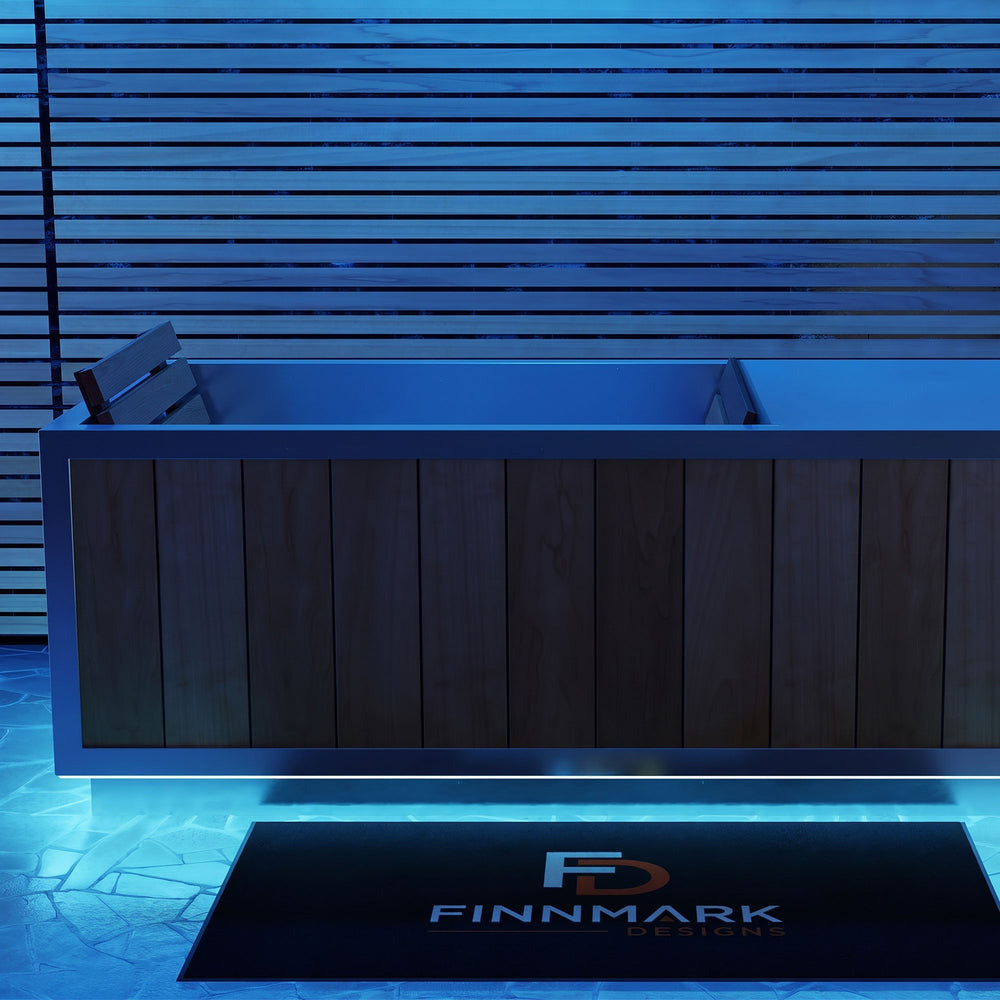 Finnmark SoulCold plunge tub with its LED lighting set to blue, beside a slatted wall